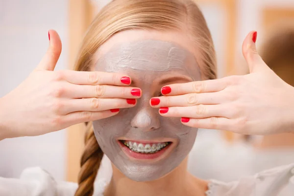 Glückliche junge Frau mit Schlammmaske im Gesicht — Stockfoto