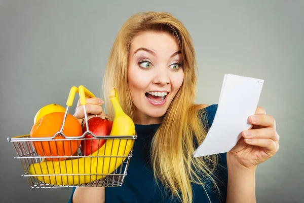 Happy woman holding shopping basket with fruits — Stock Photo, Image