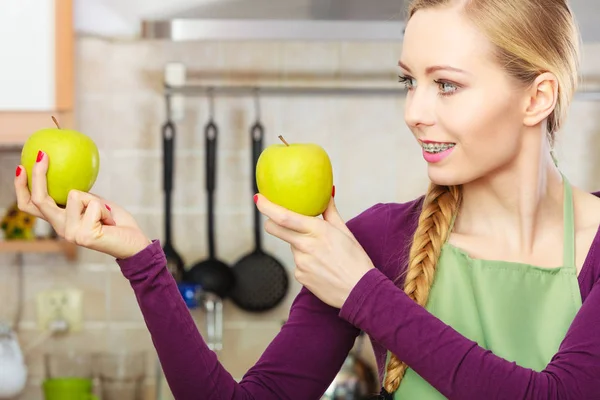 Femme jeune femme au foyer dans la cuisine avec des pommes — Photo