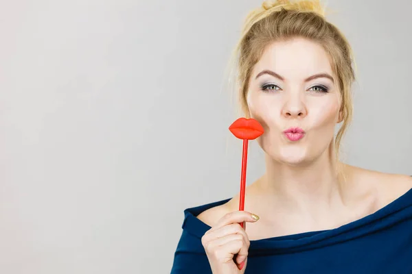 Mujer feliz sosteniendo los labios en palo —  Fotos de Stock