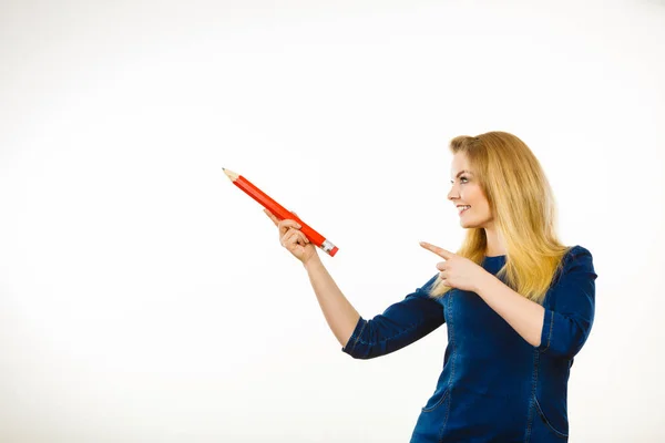 Positieve vrouw houdt grote potlood in de hand — Stockfoto