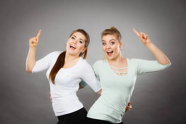 Mujeres felices señalando con un dedo . — Foto de Stock