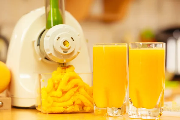 Fazendo suco de laranja na máquina do juicer na cozinha — Fotografia de Stock