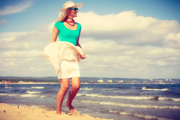 Mujer rubia usando vestido caminando en la playa —  Fotos de Stock