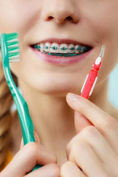 치 간 및 전통적인 브러시를 사용 하 여 치아 교정기와 소녀 — 스톡 사진