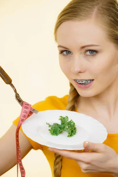 Woman on diet holding plate with lettuce — Stock Photo, Image
