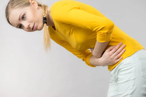 Mujer sintiendo calambres estomacales sosteniendo su vientre —  Fotos de Stock