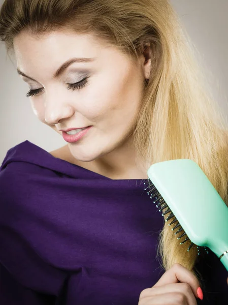Kvinna borsta hennes långa hår med borste — Stockfoto