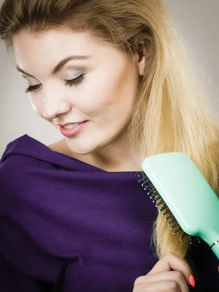 Vrouw haar lange haren borstelen met borstel — Stockfoto