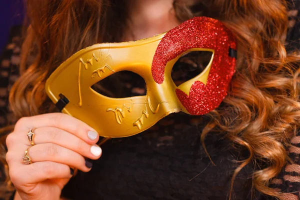 Vrouwelijke hand houdt carnaval masker closeup — Stockfoto