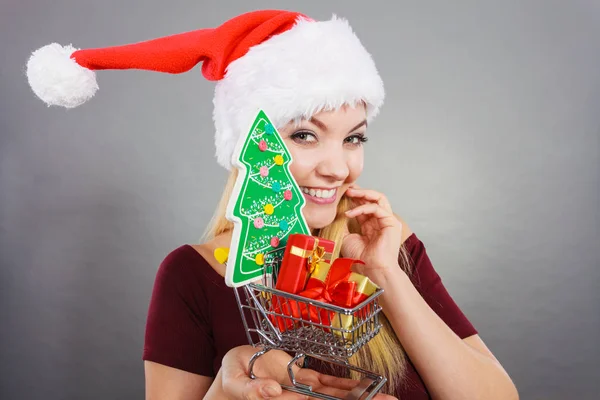 Santa woman holding shopping cart with christmas gifts — Stock Photo, Image