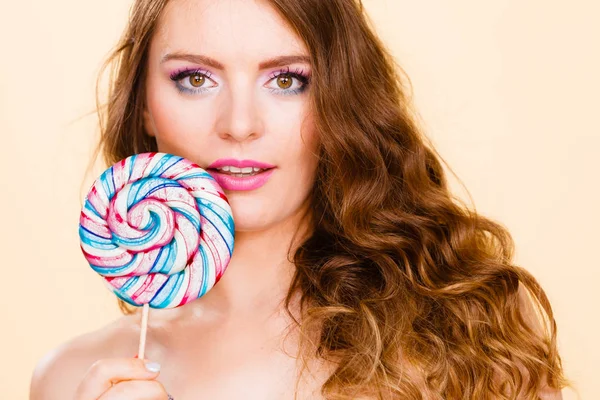 Woman holds colorful lollipop candy in hand — Stock Photo, Image