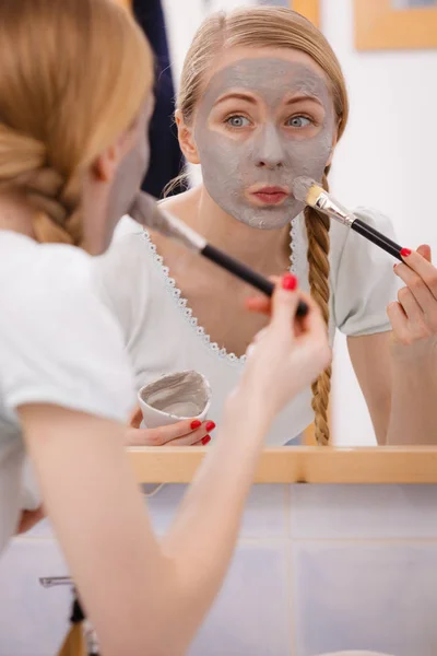 Woman with grey clay mud mask on her face — Stock Photo, Image