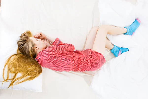 Jovem deitada na cama usando pijama — Fotografia de Stock