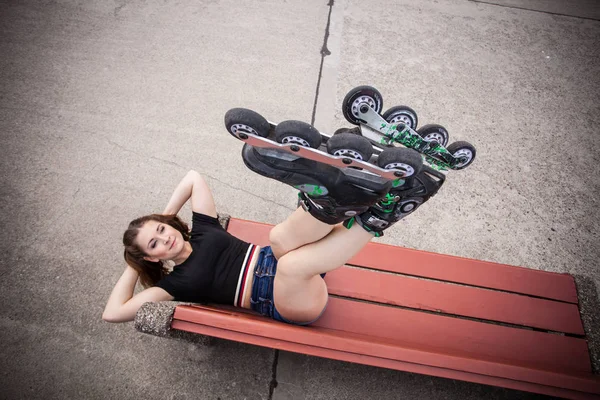 Божевільна жінка на лавці в роликових ковзанах — стокове фото