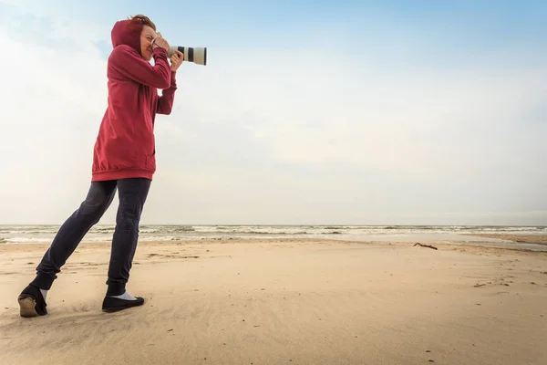 Kvinnan tar bilder på kusten — Stockfoto