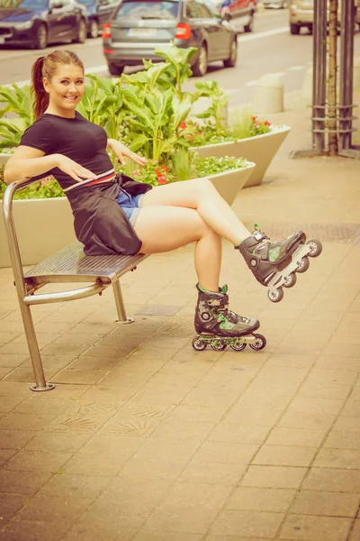 Νεαρή γυναίκα να κάθεται φορώντας πατίνια — Φωτογραφία Αρχείου