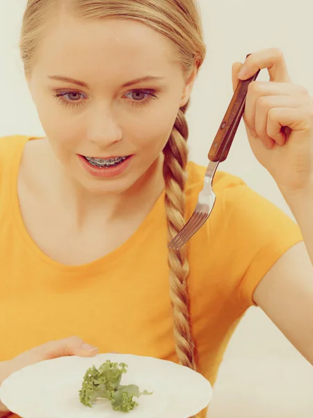 Jovem sorrindo mulher comendo alface — Fotografia de Stock