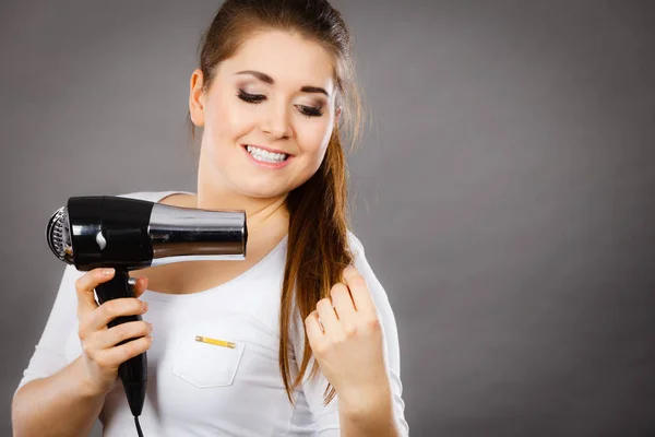 Woman drying her hair using hair dryer — Stock Photo, Image