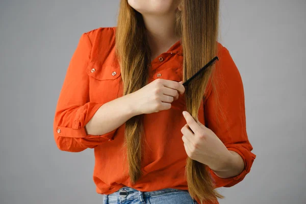 Woman combing her brown hair — Stock Photo, Image