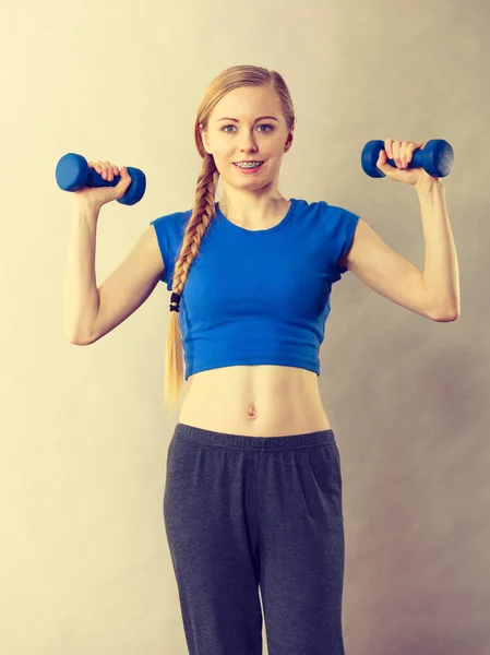 Teenage woman working out at home with dumbbell — Stock Photo, Image