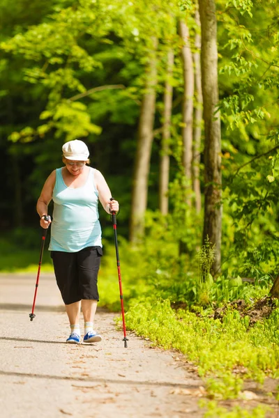 Mujer mayor practicando nordic walking en el parque —  Fotos de Stock