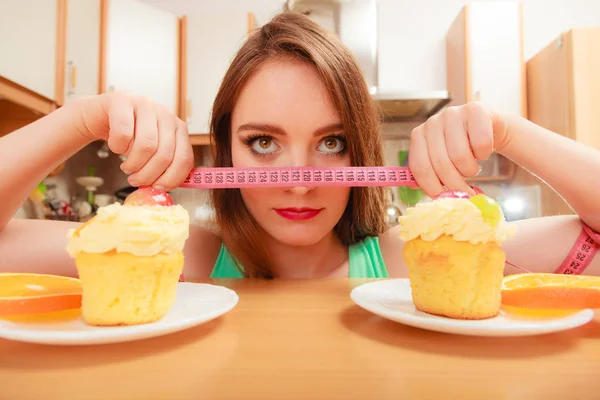 Woman with tape measure and cake. Diet dilemma. — Stock Photo, Image