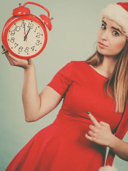 Nő visel Mikulás jelmez gazdaság óra — Stock Fotó