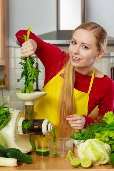 Woman in kitchen making vegetable smoothie juice — Stock Photo, Image