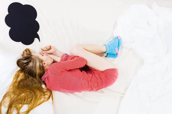 Jovem deitada na cama usando pijama — Fotografia de Stock