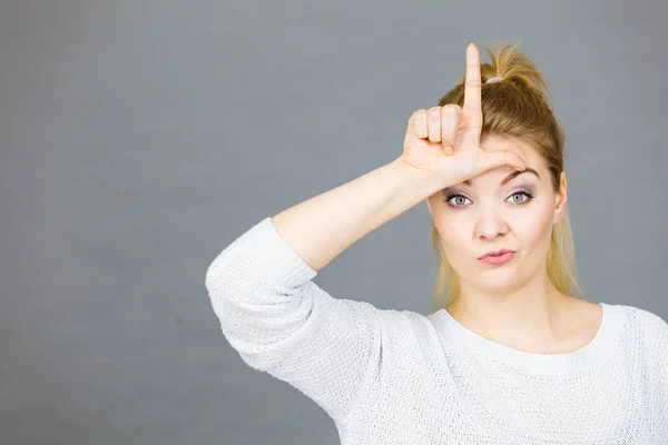 Mujer mostrando gesto perdedor con L en la frente — Foto de Stock