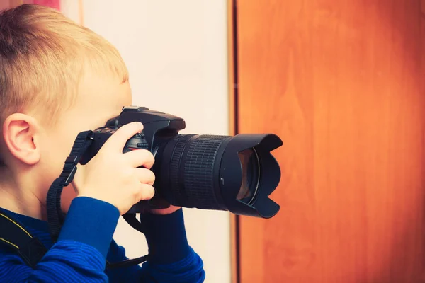 Kid playing with big professional digital camera — Stock Photo, Image