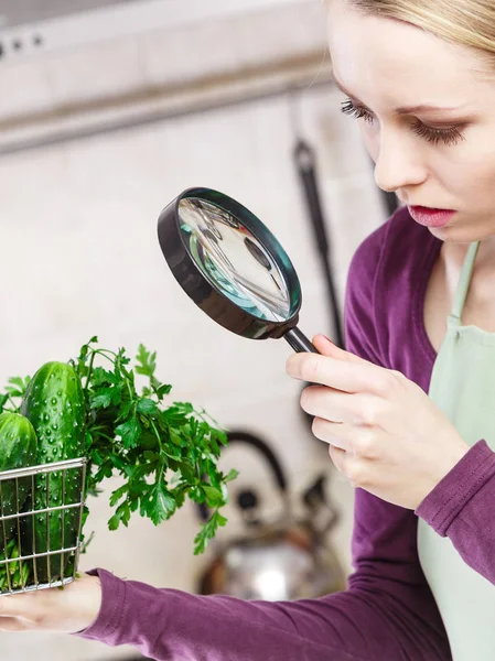 Žena při pohledu přes lupu na koš zeleniny — Stock fotografie
