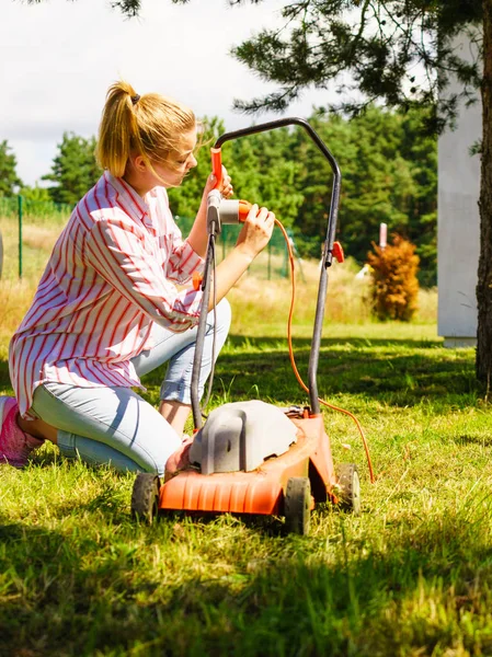 Kvinnan att klippa gräsmattan med gräsklippare — Stockfoto