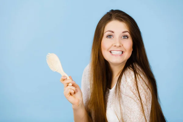 Mujer feliz sosteniendo cepillo a punto de cepillarse el pelo — Foto de Stock