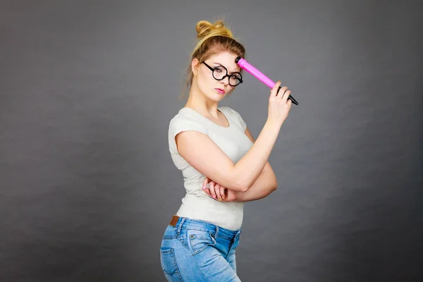 Mujer sosteniendo un gran lápiz de gran tamaño pensando en algo — Foto de Stock