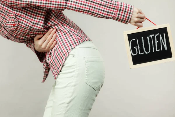 Mulher sentindo cãibras no estômago segurando placa de glúten — Fotografia de Stock