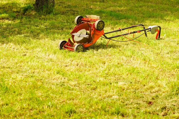 Gebroken oude grasmaaier in gras van de achtertuin — Stockfoto