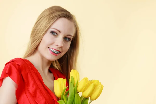 Mooie vrouw met gele tulpen bos — Stockfoto