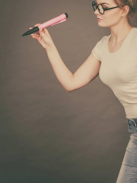Kvinna med stora överdimensionerade penna tänka på något — Stockfoto