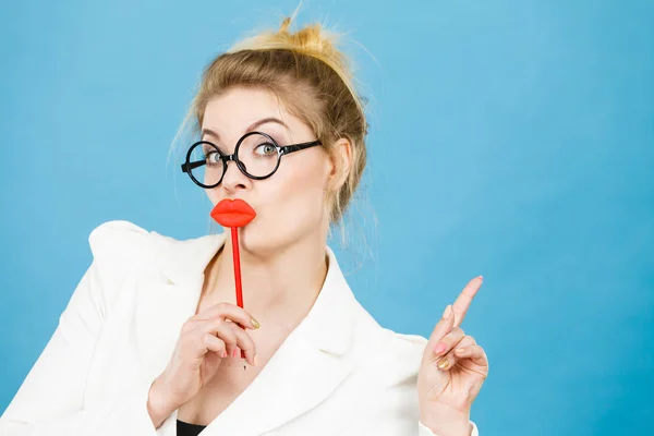 Mujer sostiene labios falsos en palo apuntando al espacio de copia — Foto de Stock