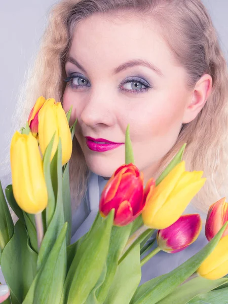 Jolie femme avec bouquet de tulipes jaunes rouges — Photo