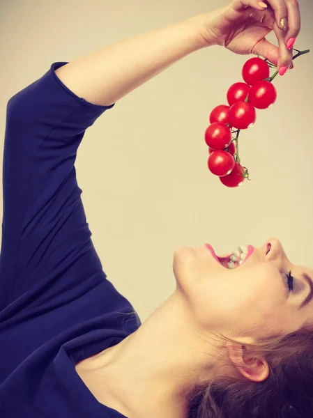Mujer sosteniendo comer tomates cherry frescos — Foto de Stock