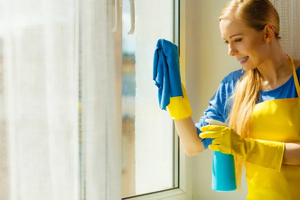 Παράθυρο καθαρισμού κοριτσιών στο σπίτι χρησιμοποιώντας απορρυπαντικό κουρέλι — Φωτογραφία Αρχείου