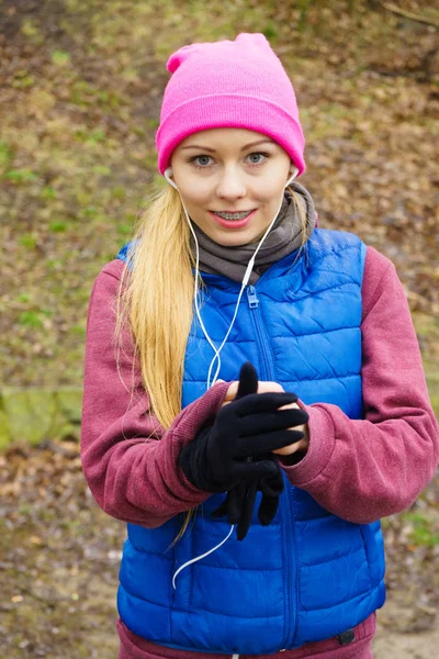 Sportliches Mädchen im Teenager-Alter hört Musik im Freien. — Stockfoto