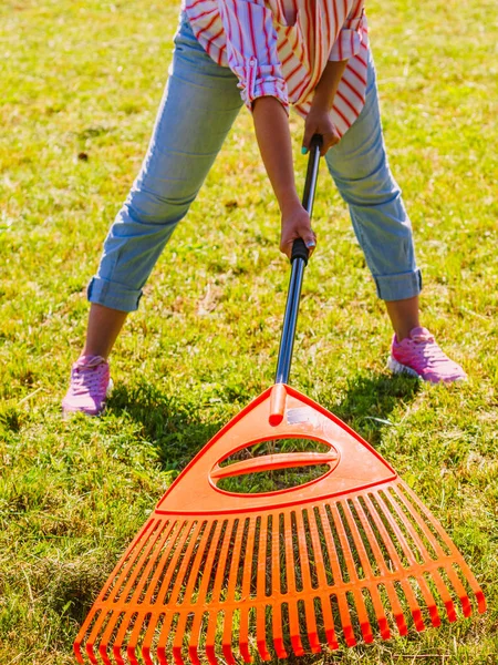 Mujer usando rastrillo para limpiar el césped del jardín —  Fotos de Stock