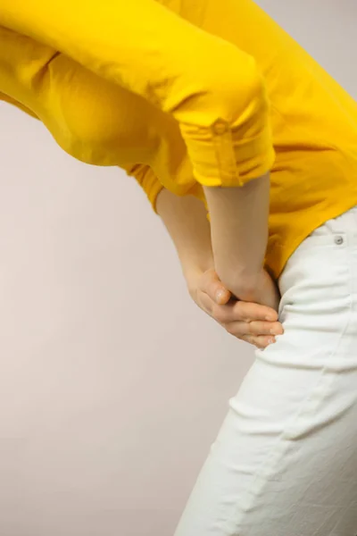 Vrouw met handen met haar kruis — Stockfoto