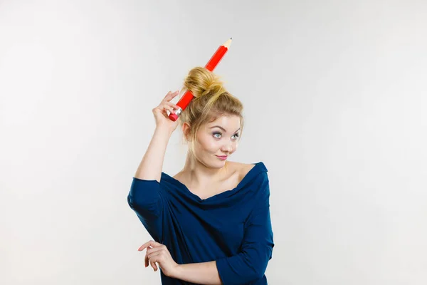 Mujer rubia feliz teniendo lápiz grande en el pelo —  Fotos de Stock