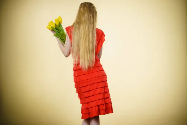 Женщина с желтыми тюльпанами, вид сзади — стоковое фото