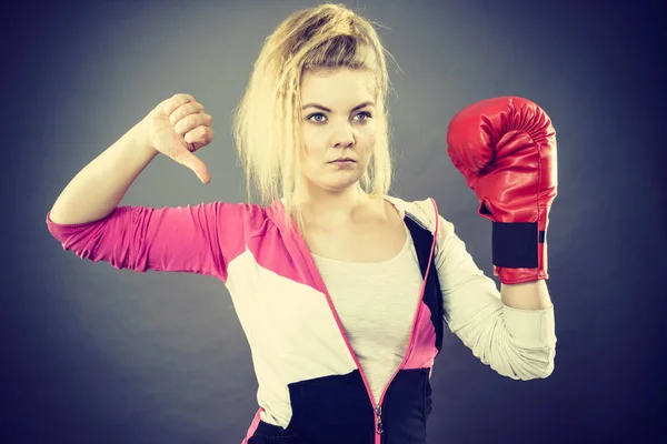 Mujer usando guantes de boxeo mostrando el pulgar hacia abajo —  Fotos de Stock